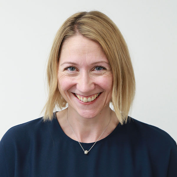 Elaine smiles at the camera, she has short blonde hair and a blue top.